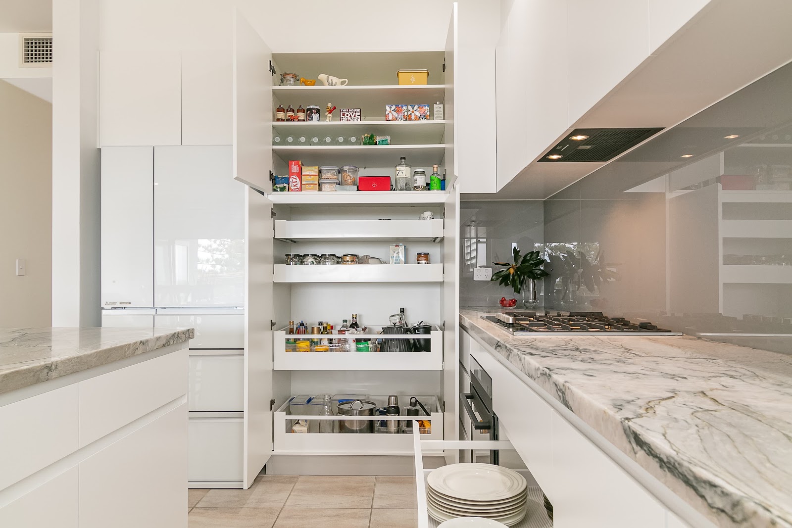 Open pull-out pantry beside a marble-look benchtop