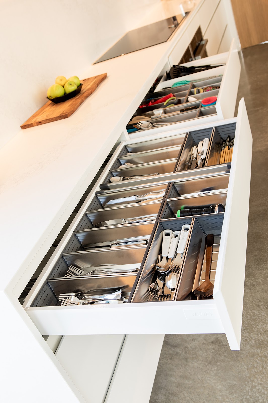 Long white drawer open with stainless organiser inserts